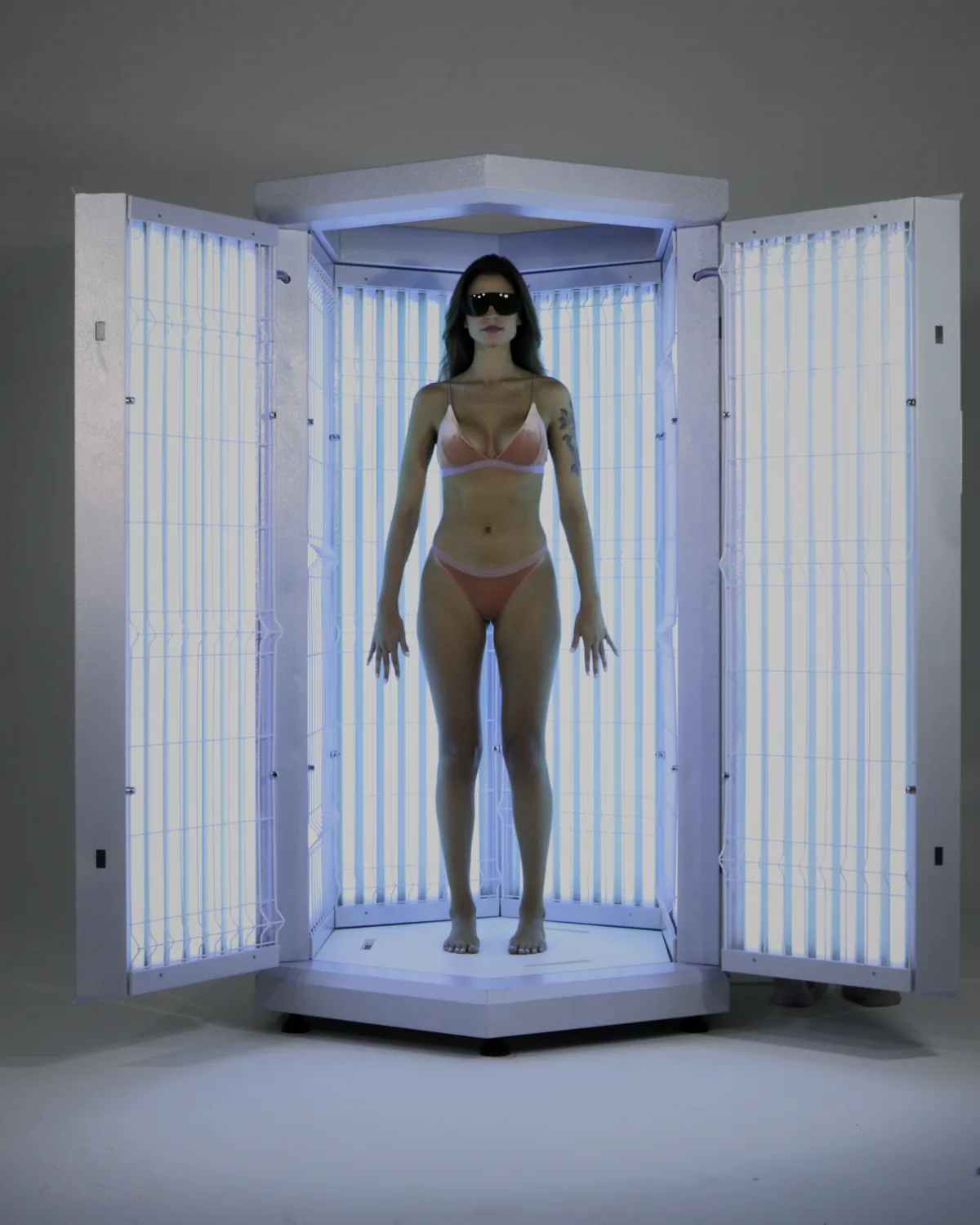 Paciente com óculos de proteção durante sessão na cabine de fototerapia Prolumina Professional